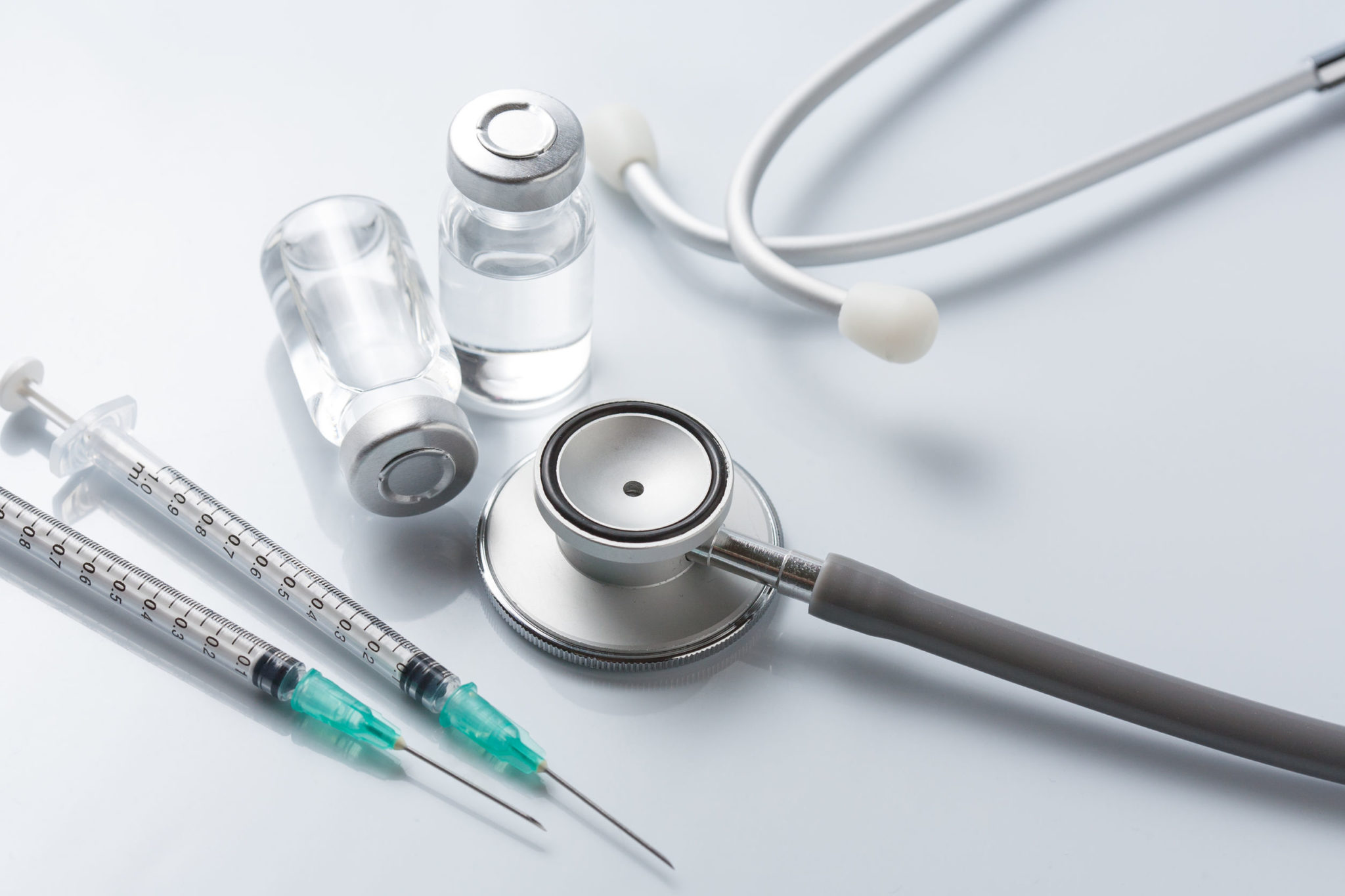 Medical equipment : stethoscope ampoules and syringe on white ba